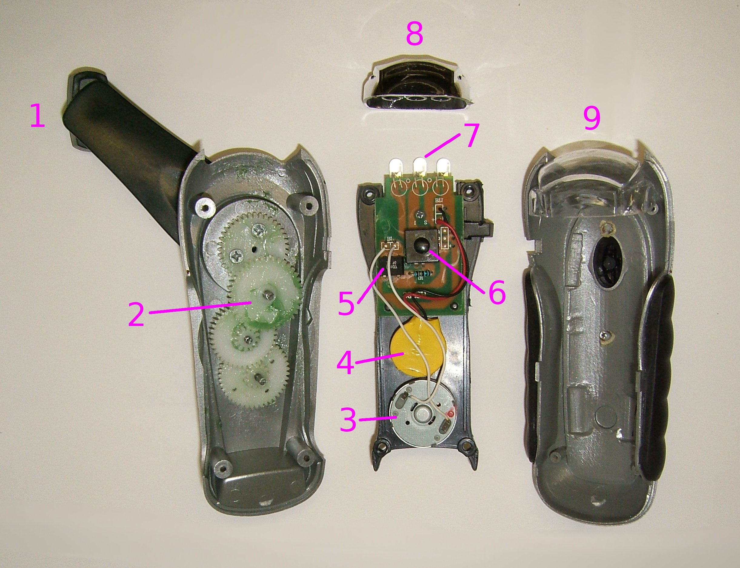 Zerlegte Handkurbel-Notfallleuchte mit sichtbarem Akku, Generator und LED-Einheit.