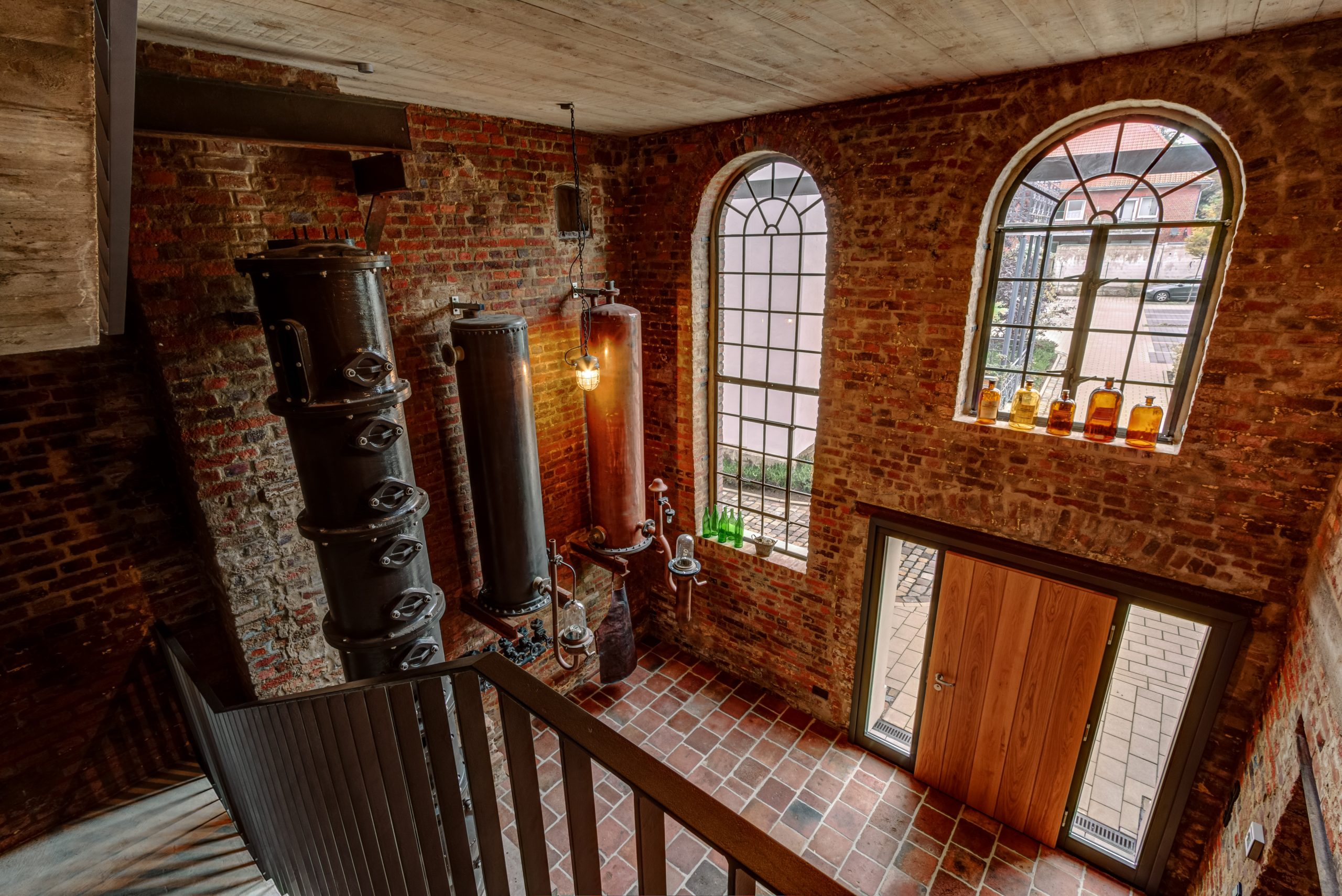 Innenliegendes Treppenhaus mit mehreren Läufen, Podesten und sichtbarer Beleuchtung.
