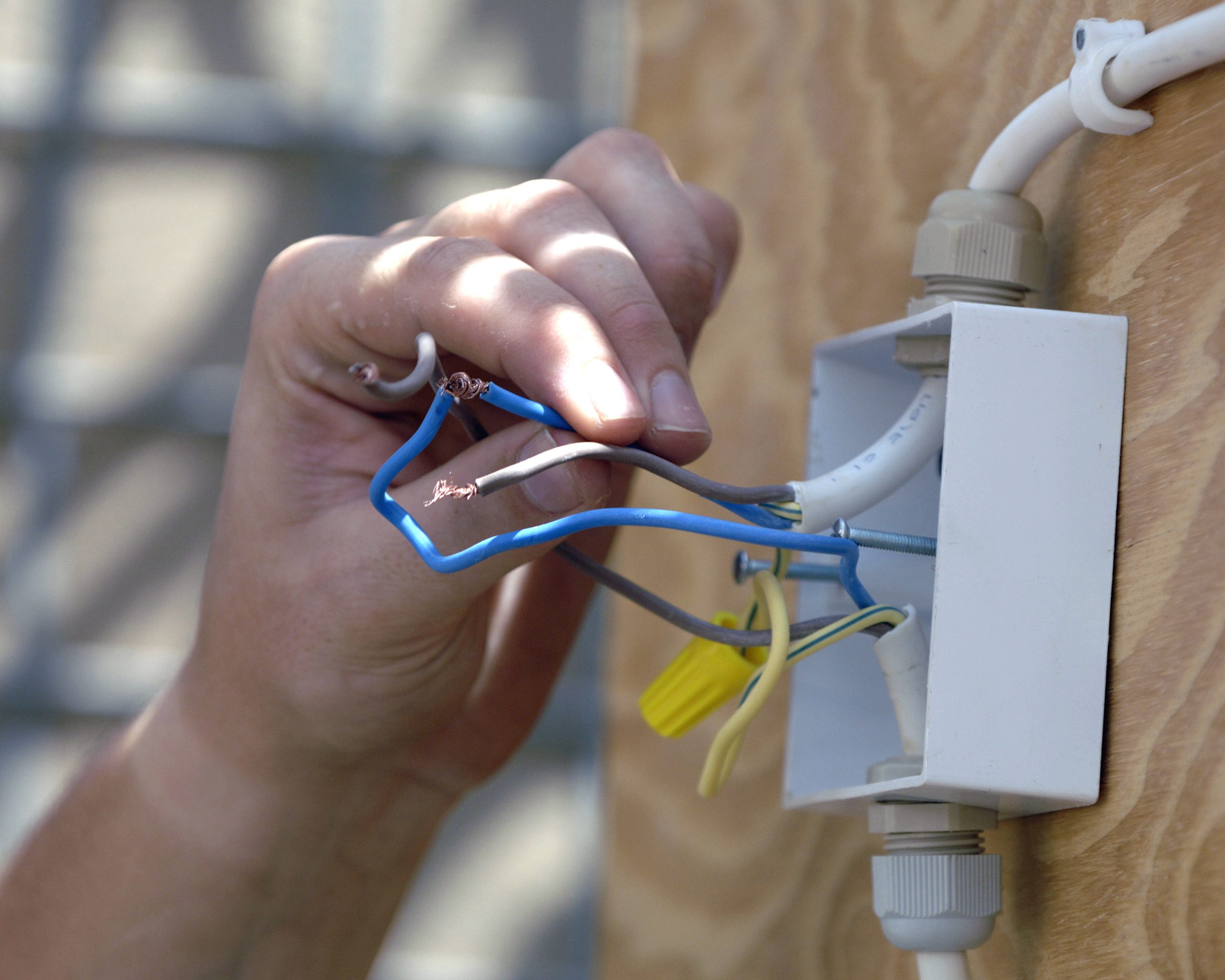 Elektroausbilder prüft die Verdrahtung eines neu installierten Stromanschlusses