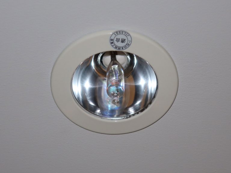 Runde deckenmontierte Notleuchte mit Halogenlampe in einem Gebäude.