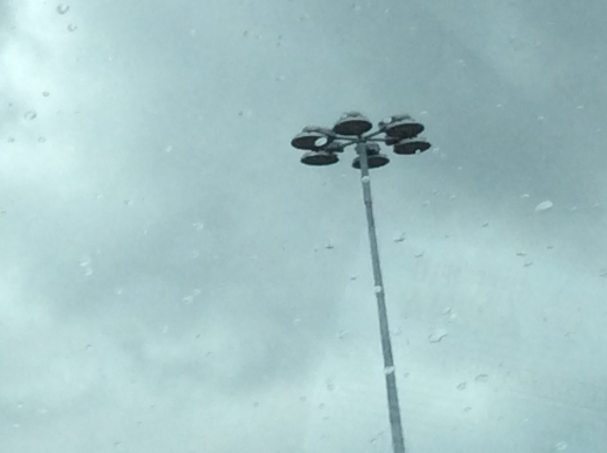 Hoher Mast mit mehreren Flutlichtleuchten vor dem Gelände einer Arena in Sheffield.