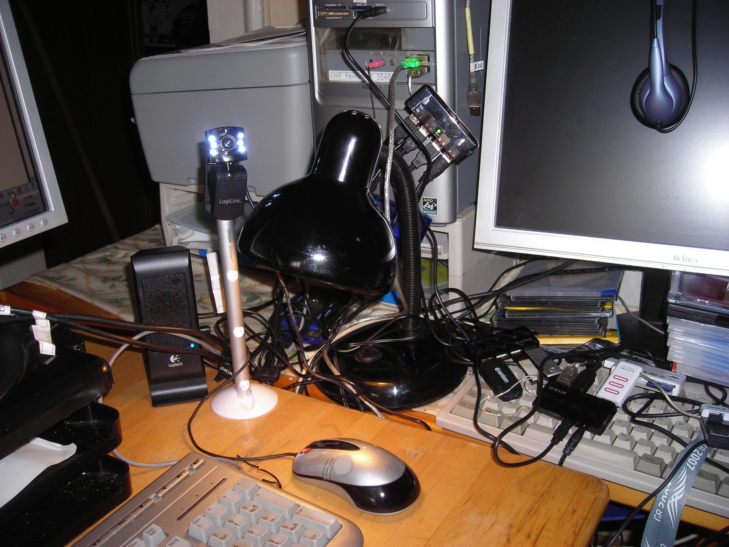 Schreibtisch mit zwei Computerbildschirmen, Tastatur und seitlicher Raumbeleuchtung.
