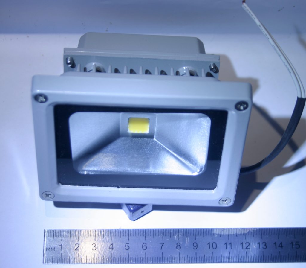 Kompakter feuchtegeschützter LED-Außenstrahler mit Metallgehäuse und Anschlussleitung.