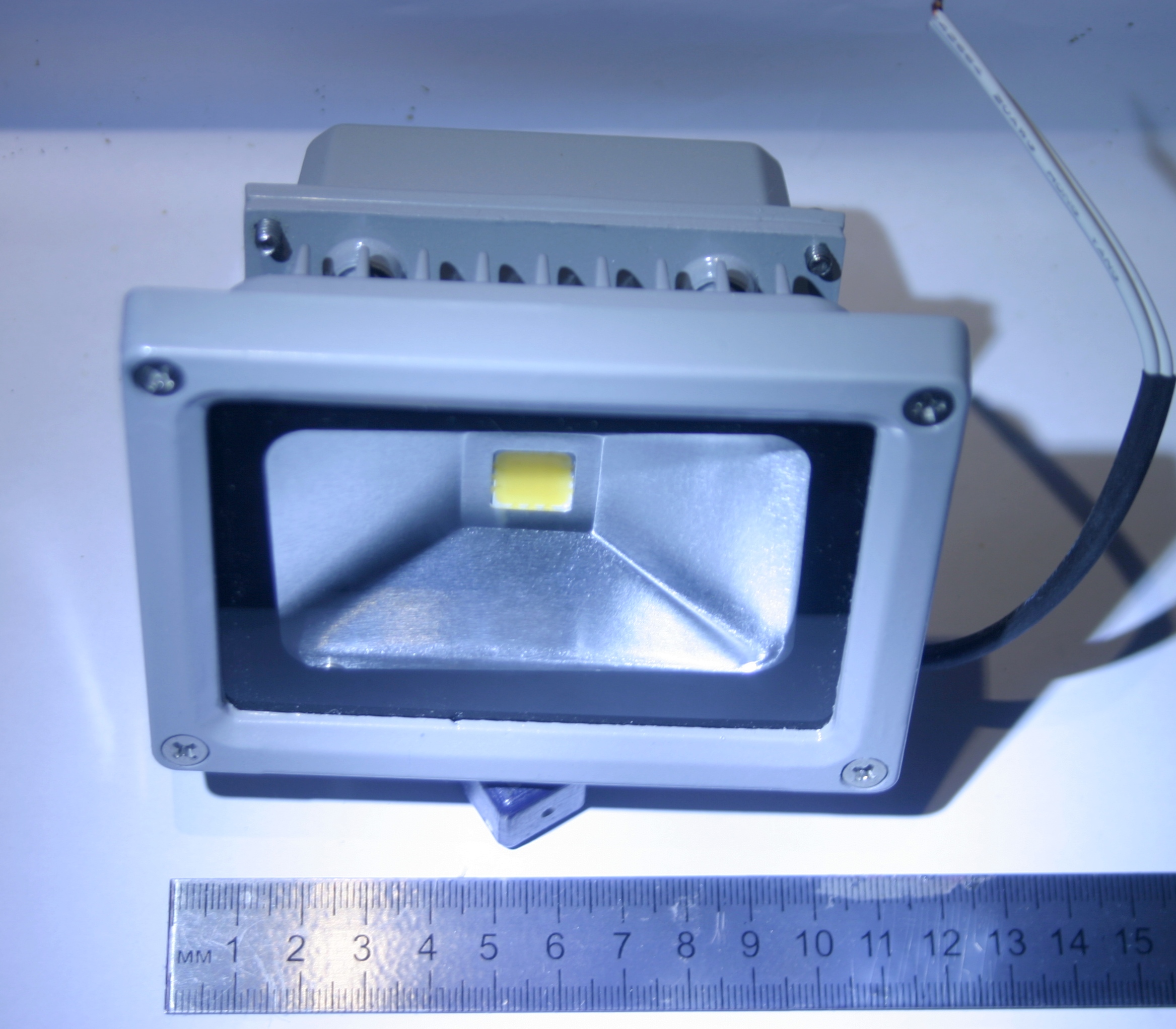 Kompakter feuchtegeschützter LED-Außenstrahler mit Metallgehäuse und Anschlussleitung.