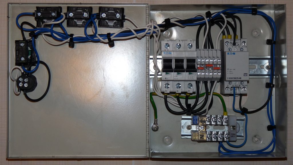 Geöffnete Schalttafel mit Schützen, Sicherungen und Steuerkomponenten für Außenleuchten