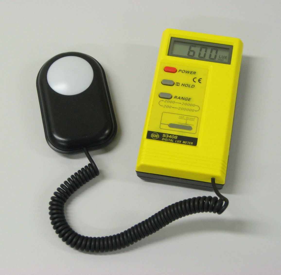 Digitales Luxmeter mit separatem Lichtsensor auf einer Arbeitsfläche.