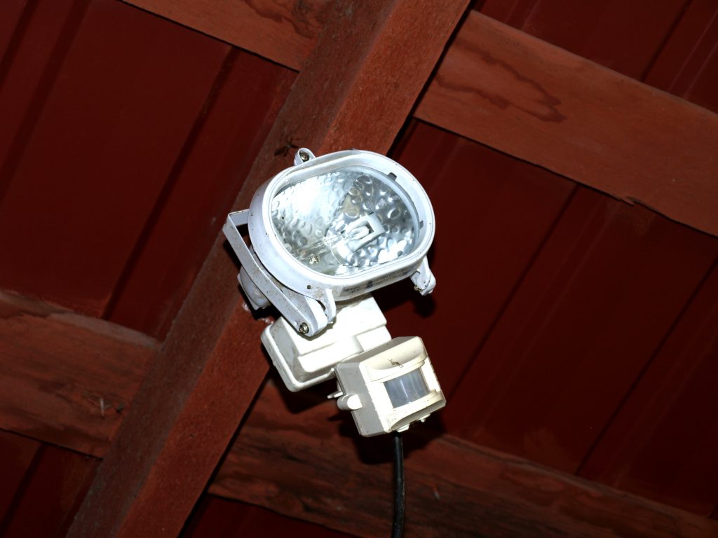 Wandmontierter Bewegungssensor mit Leuchte für eine automatische Lichtsteuerung.