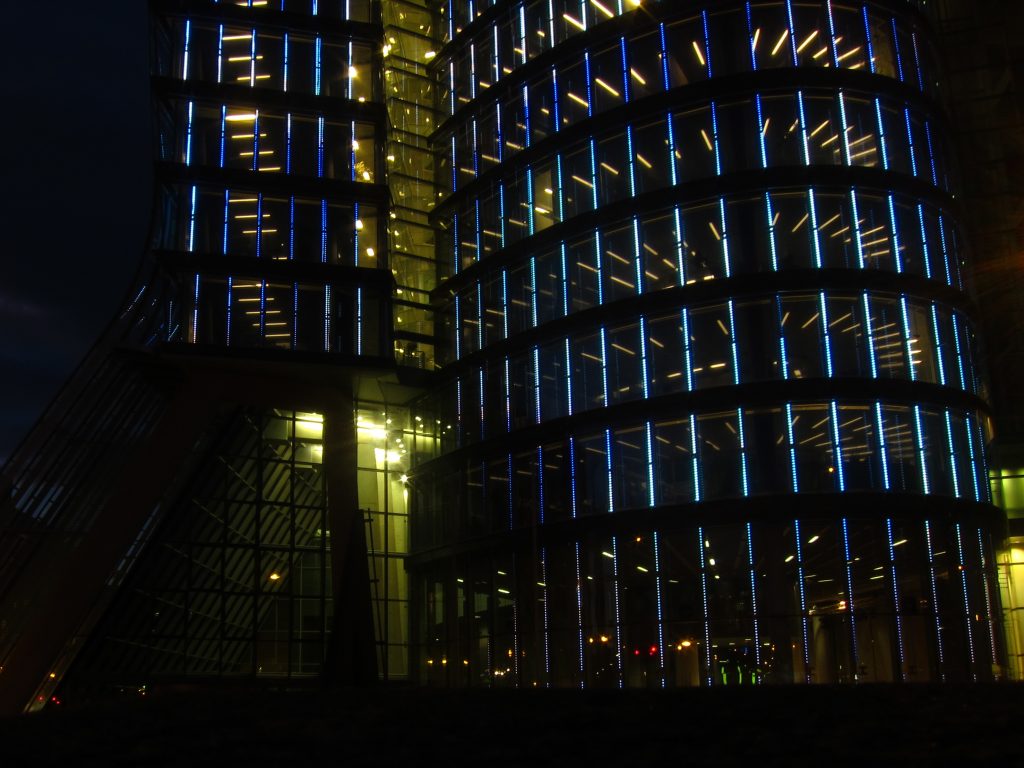 Bürogebäude in Wien mit zahlreichen beleuchteten Fenstern bei Nacht.