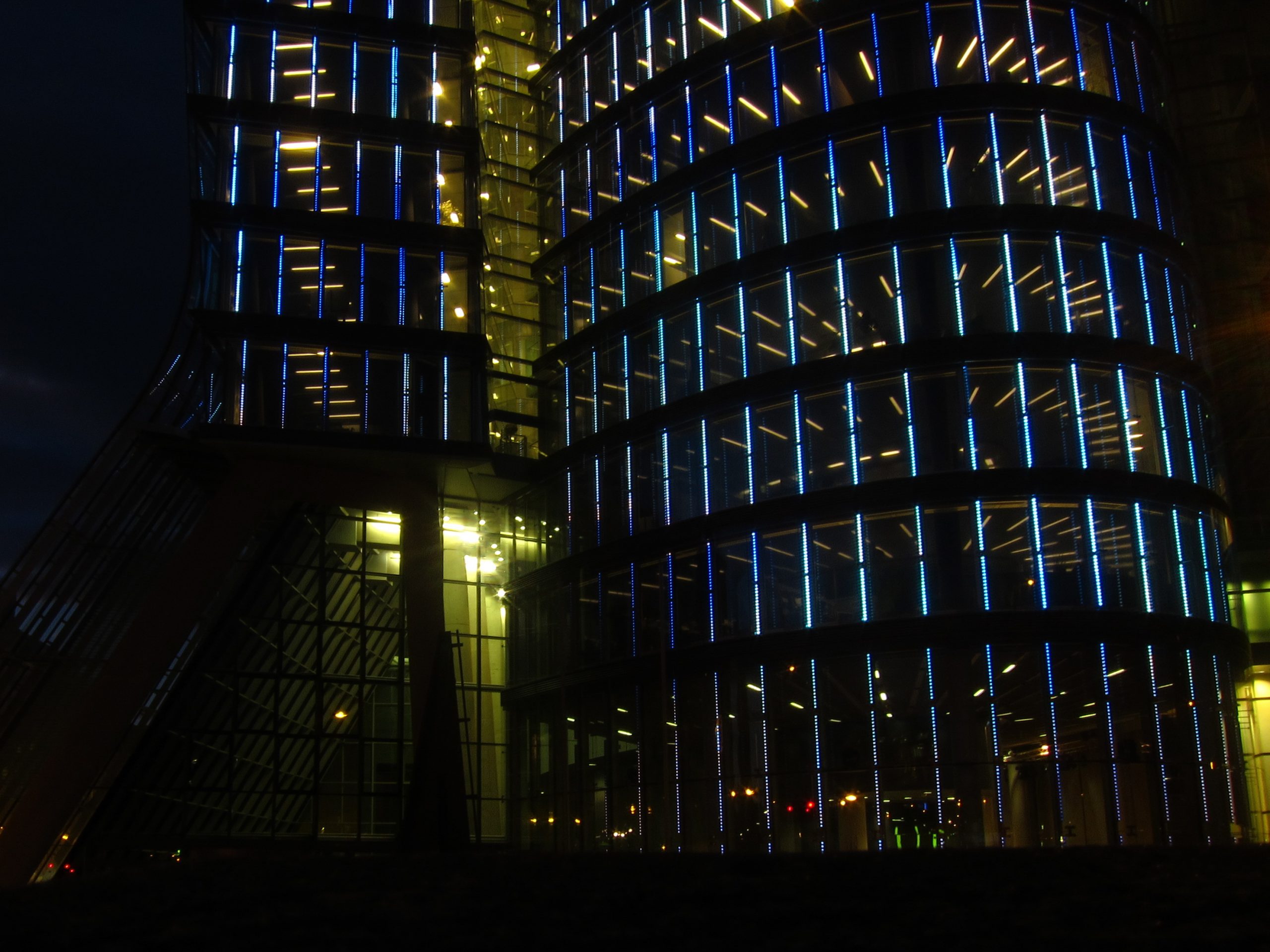 Bürogebäude in Wien mit zahlreichen beleuchteten Fenstern bei Nacht.