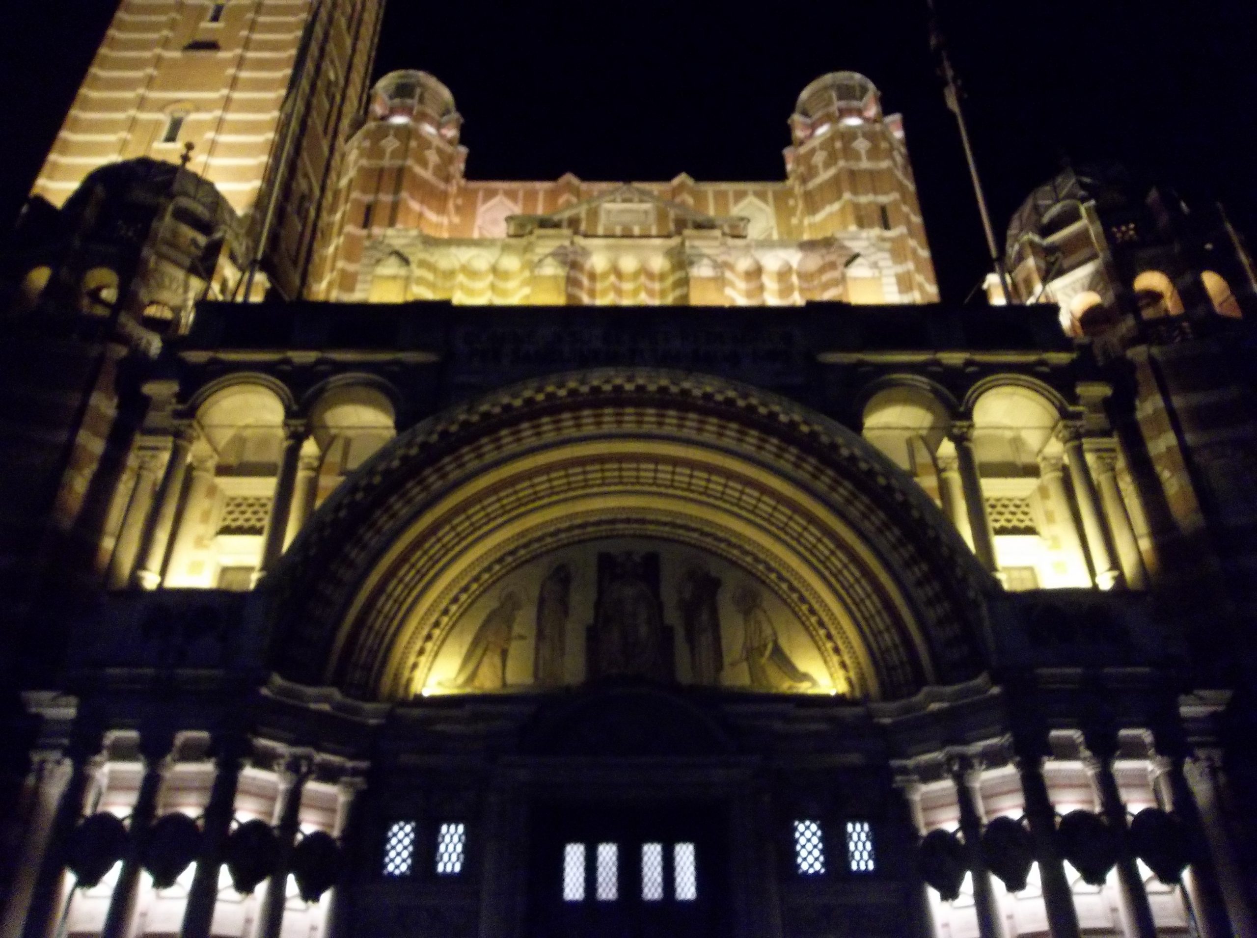 Breite Backsteinfassade der Westminster Cathedral mit gleichmäßiger Beleuchtung bei Nacht